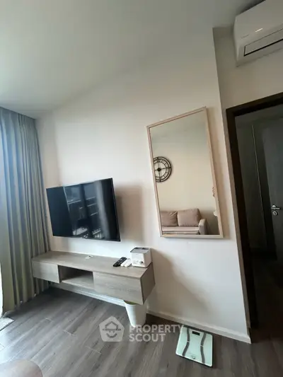 Modern living room with wall-mounted TV and stylish decor in a cozy apartment.