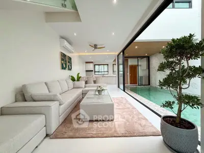 Luxurious living room with pool view, modern decor, and open layout for ultimate relaxation.