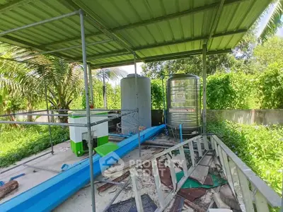 Outdoor utility area with water tanks and green metal roof