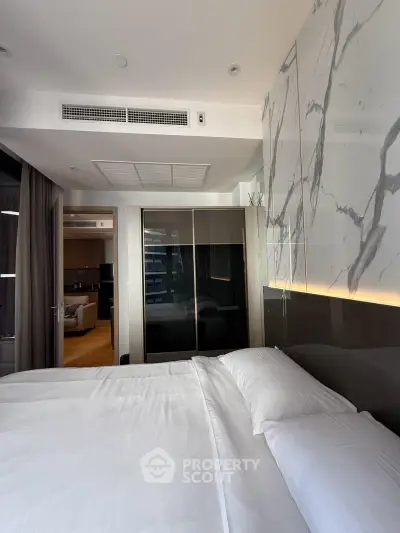 Luxurious bedroom with marble accent wall and modern design in upscale apartment