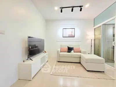Modern living room with sleek furniture and large TV, perfect for relaxation and entertainment.