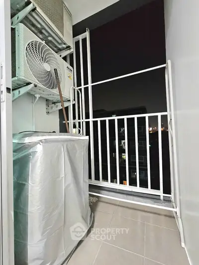 Compact balcony with air conditioning unit and night city view