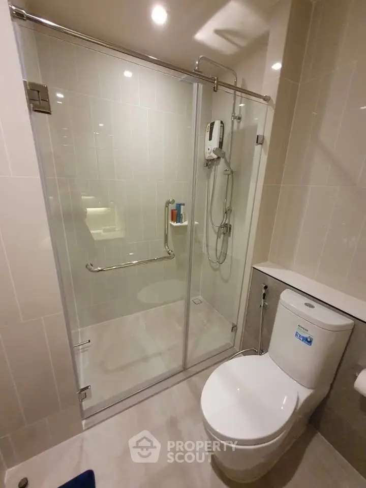 Modern bathroom with glass shower enclosure and sleek toilet design.
