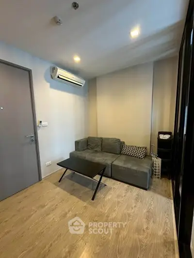 Modern living room with sleek sofa and air conditioning, perfect for cozy relaxation.