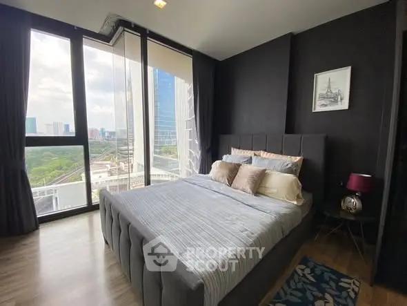 Modern bedroom with large windows offering stunning city views.