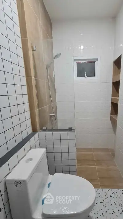 Modern bathroom with shower and tiled walls in a sleek design.