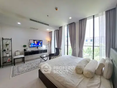 Spacious bedroom with large windows and modern decor in a luxury apartment.