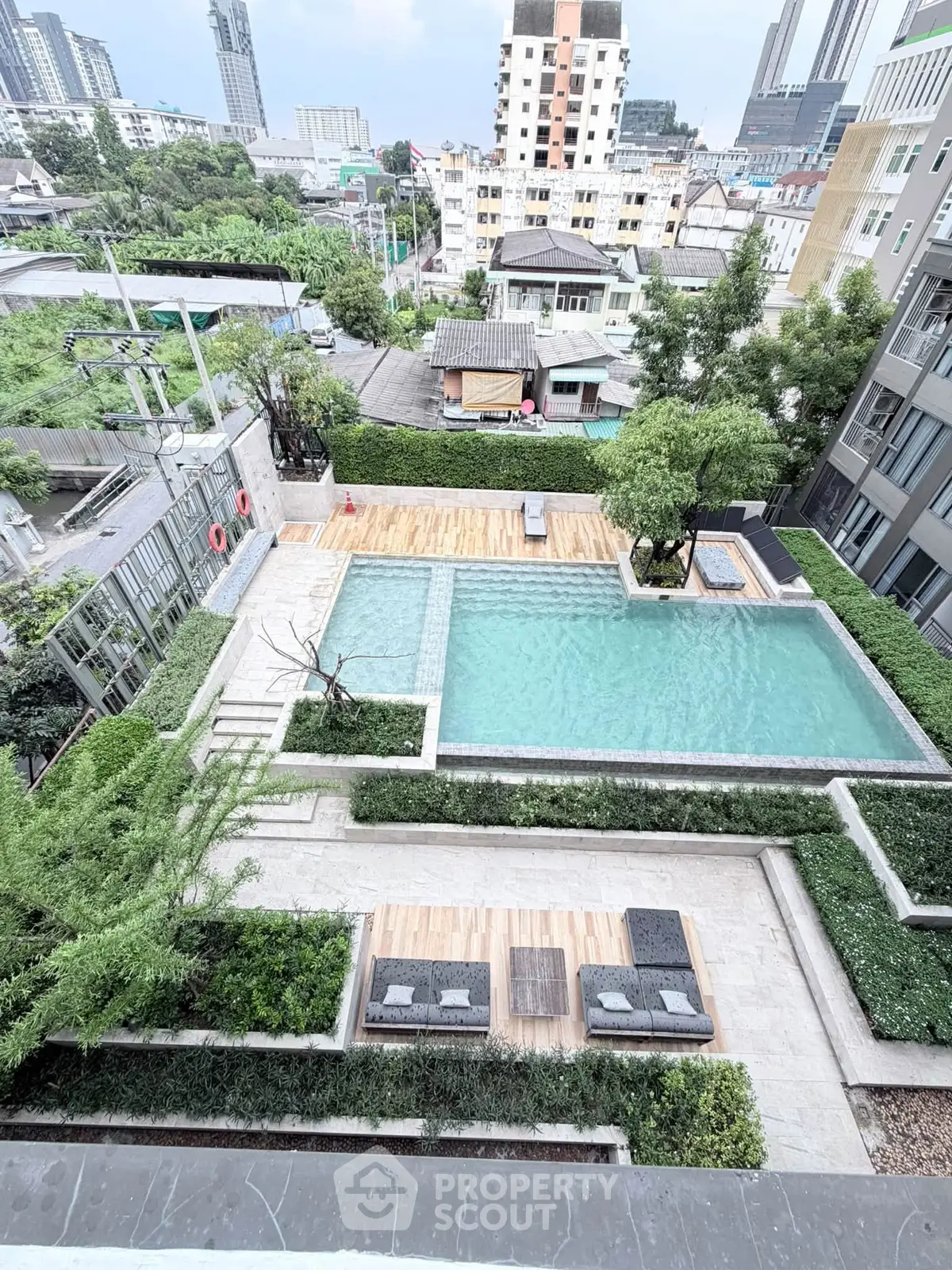 Luxurious rooftop pool with stunning city views and lush greenery in a modern residential complex.