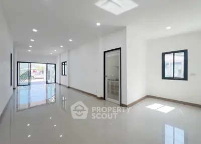 Spacious modern living room with glossy tile flooring and ample natural light