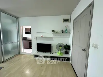 Modern living room with sleek TV setup and open kitchen view