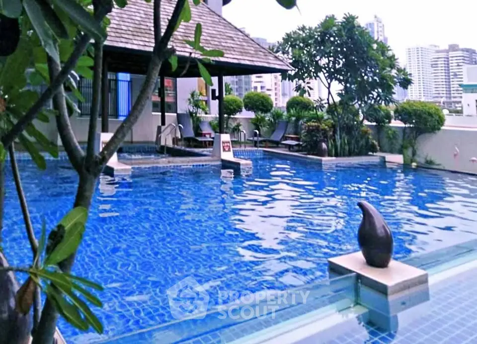 Luxurious rooftop pool with city views and lush greenery, perfect for relaxation and leisure.