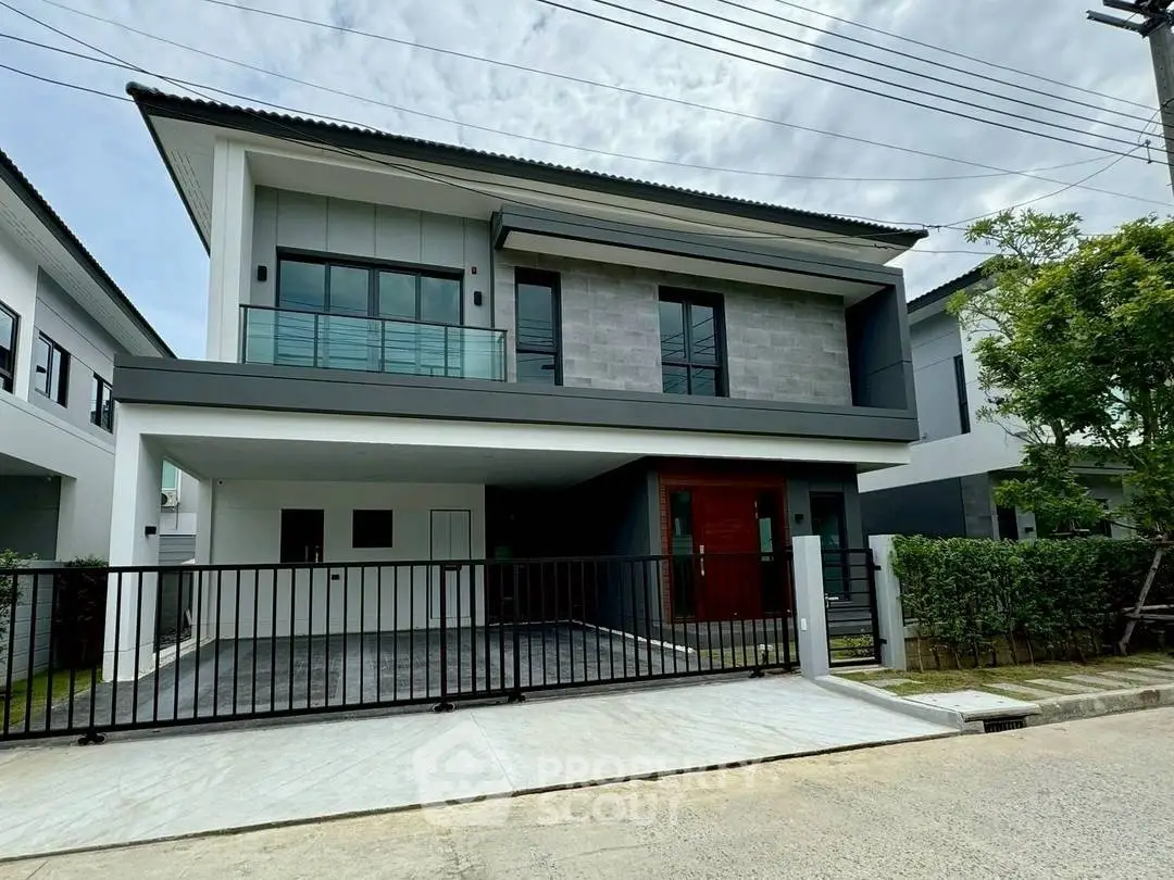 Modern two-story house with sleek design and spacious driveway in a suburban neighborhood.