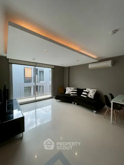 Modern living room with sleek design and large windows offering natural light.