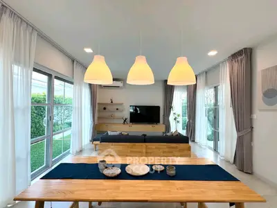 Spacious modern living room with large windows and elegant dining area