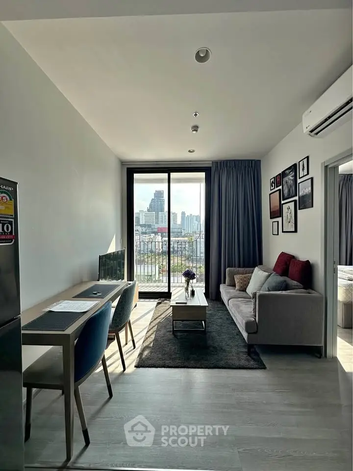 Modern living room with city view, stylish decor, and natural light in a high-rise apartment.