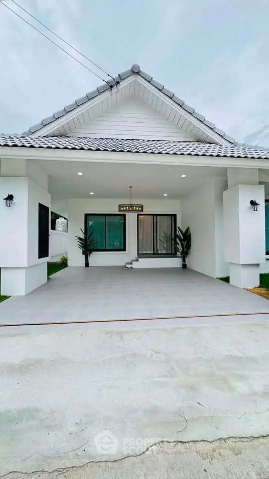 Charming modern house with white facade and spacious driveway, perfect for family living.