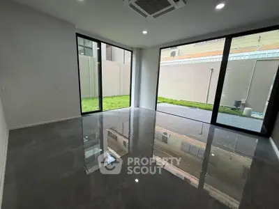 Spacious modern living room with large windows and glossy floors