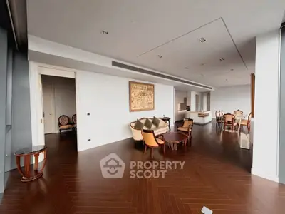 Luxurious open-plan living and dining area with elegant furnishings and hardwood floors.