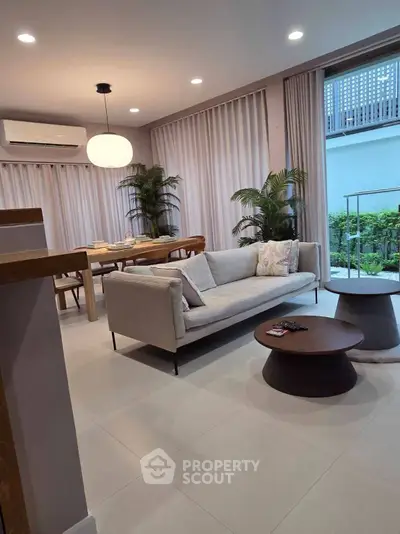 Modern living room with elegant decor and natural light, featuring a cozy sofa and stylish coffee table.
