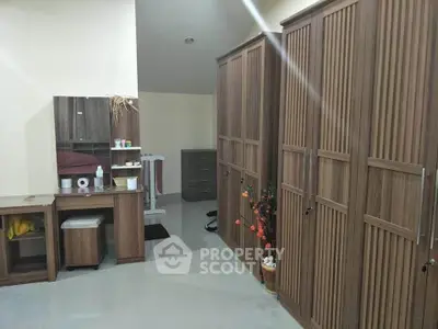 Spacious bedroom with ample wooden storage and modern decor