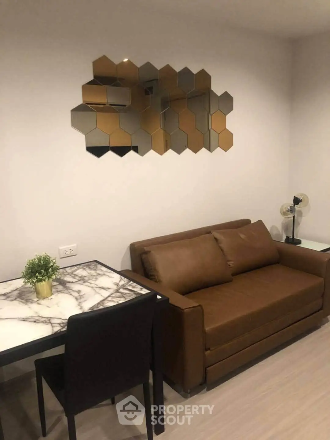 Modern living room with stylish hexagonal mirror and brown sofa