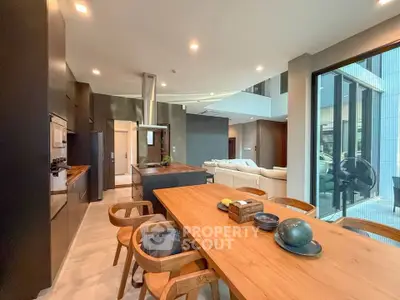Modern open-layout kitchen and living room with sleek design and natural light.