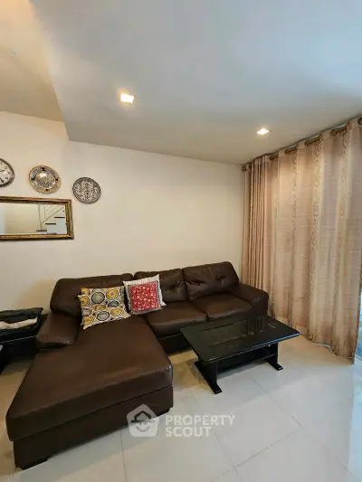 Cozy living room with stylish brown leather sectional sofa and elegant decor accents.