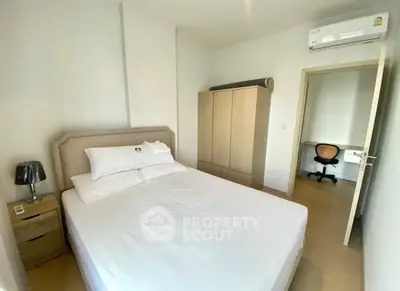 Cozy bedroom with modern furnishings and adjacent study area, perfect for comfortable living.