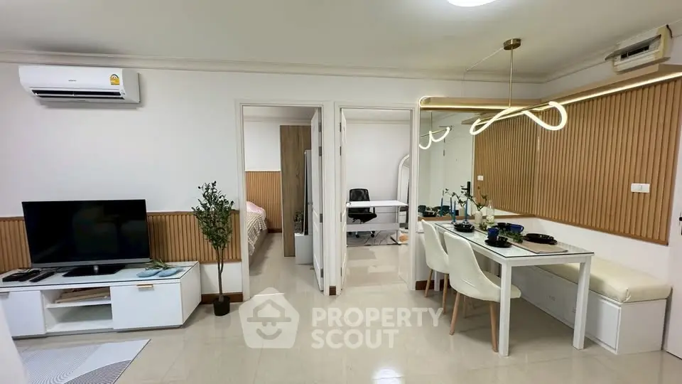 Modern living room with dining area and study, featuring sleek furniture and contemporary lighting.