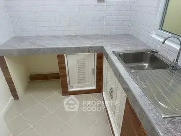 Modern kitchen with sleek countertops and stainless steel sink in a compact layout.