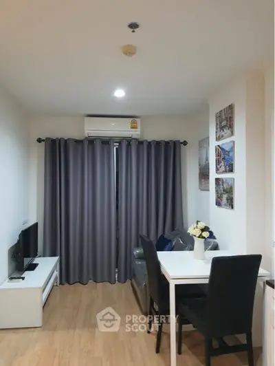 Cozy and well-lit living space with modern furnishings, elegant grey curtains, and a sleek dining set, perfect for intimate gatherings and relaxation.