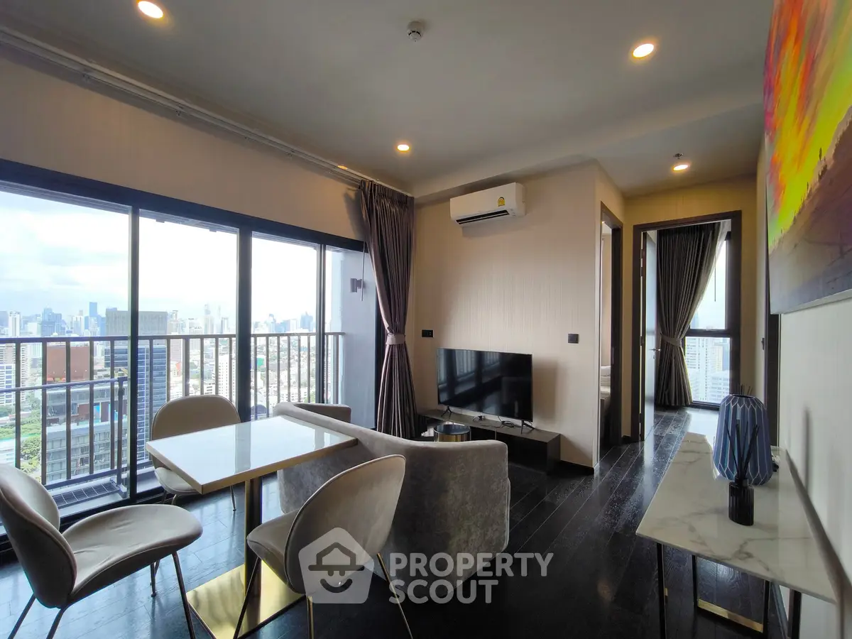 Modern living room with city view, featuring sleek furniture and large windows for natural light.