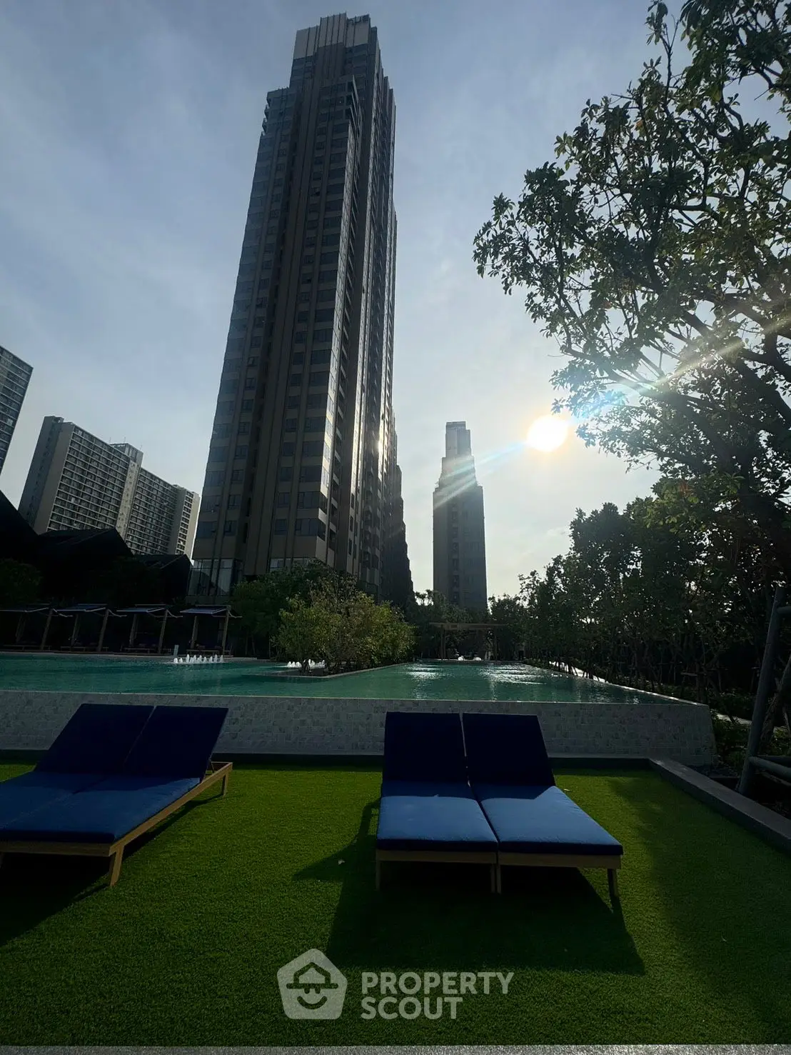 Luxurious garden with sun loungers and lush greenery, perfect for relaxation.