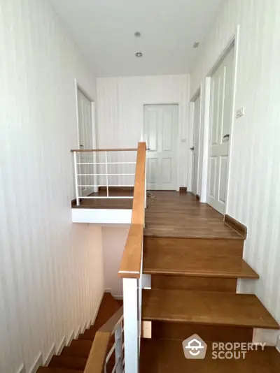 Elegant wooden staircase with modern railing in a bright hallway