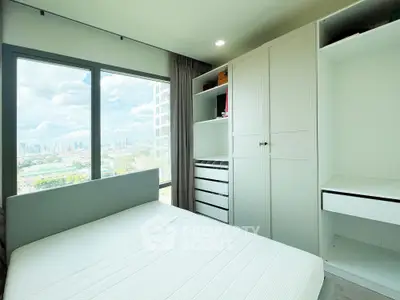 Bright bedroom with city view, featuring built-in wardrobe and large window for natural light.
