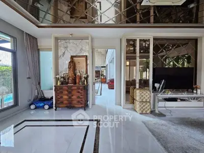 Luxurious living room with elegant decor and large windows offering natural light and pool view.