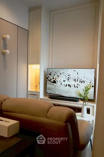 Cozy living room with modern decor and flat-screen TV, perfect for relaxation.
