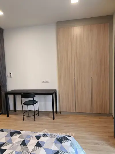 Modern bedroom with wooden wardrobe and sleek black desk, perfect for urban living.