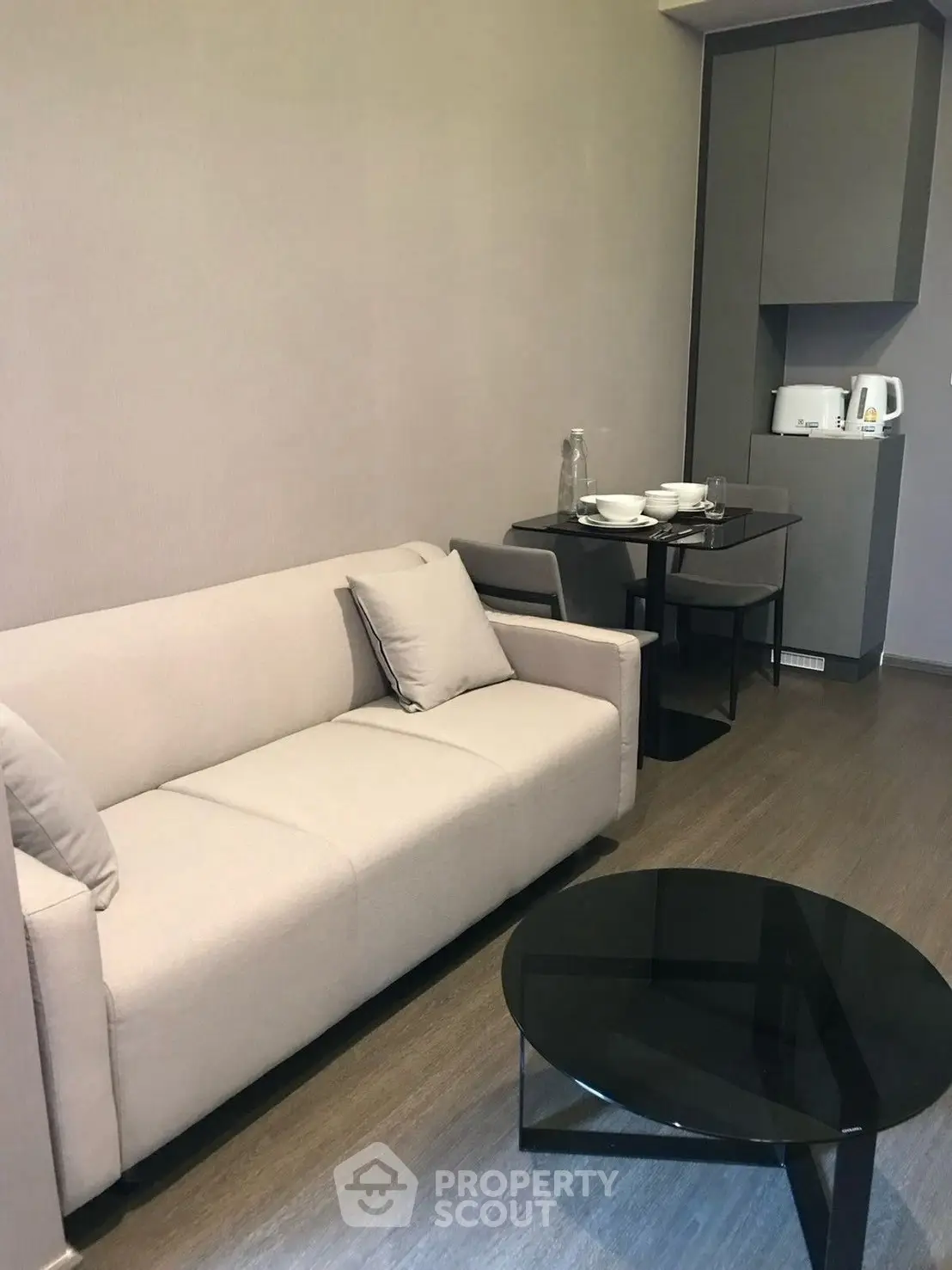 Modern living room with sleek furniture and compact dining area, perfect for urban living.