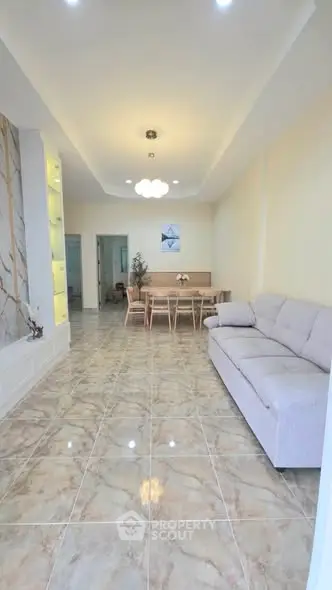 Spacious living room with elegant marble flooring and modern furniture, perfect for family gatherings.
