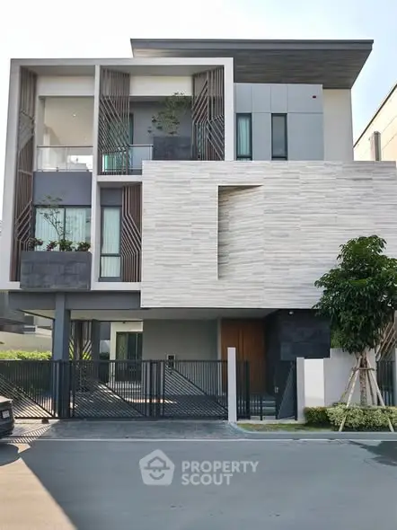 Modern three-story house with sleek design and gated entrance