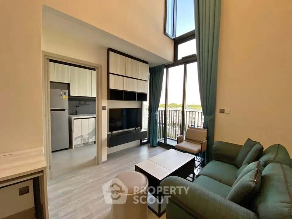 Modern living room with high ceilings and large windows offering natural light and scenic views.