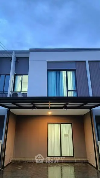 Modern townhouse exterior with sleek design and large windows at dusk.