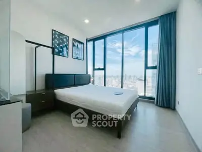 Luxurious bedroom with floor-to-ceiling windows offering stunning city views, modern decor, and ample natural light.