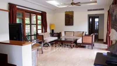 Spacious living room with elegant wooden furniture and large windows