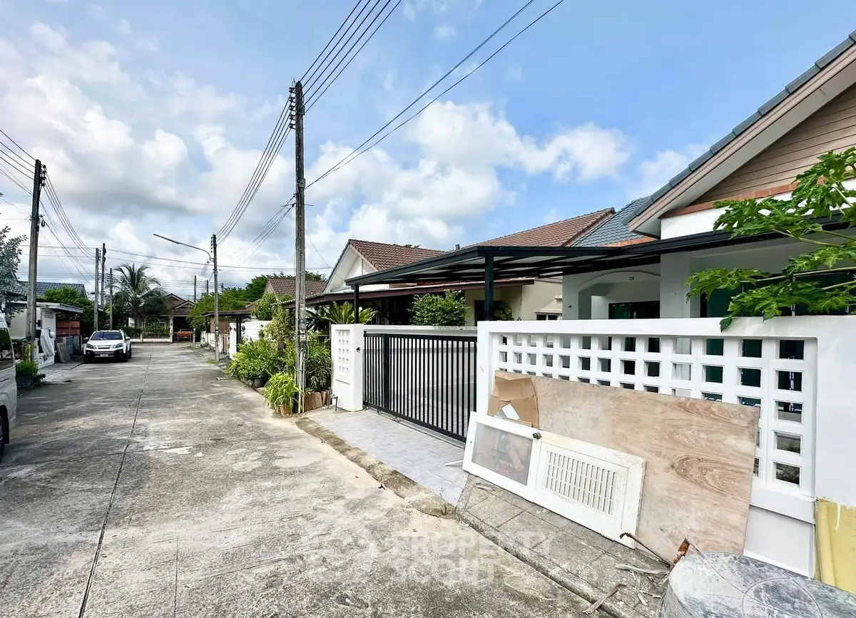 Charming suburban street view with modern single-story homes and lush greenery.
