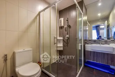 Modern bathroom with glass shower enclosure and stylish vanity unit.