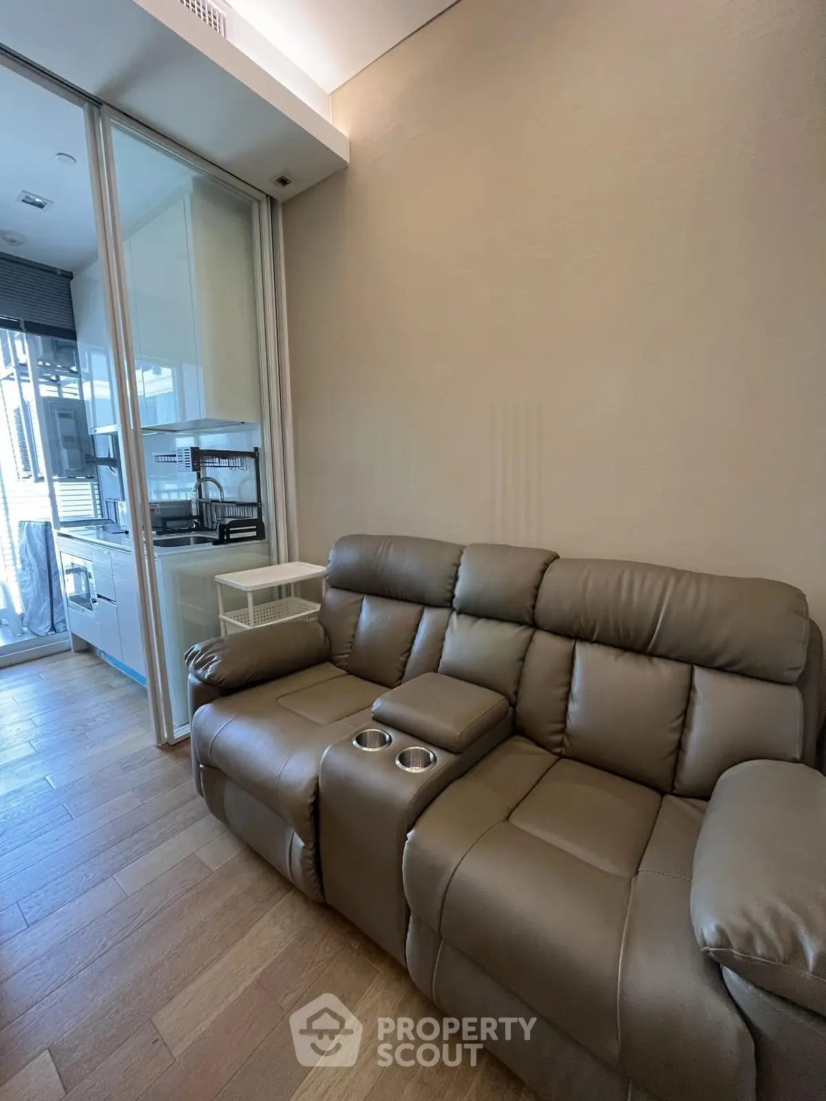 Modern living room with leather recliner and open kitchen layout