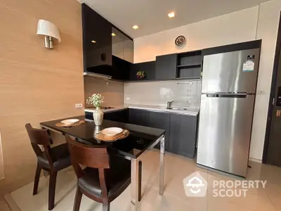 Modern kitchen with sleek black cabinets and dining area in contemporary apartment