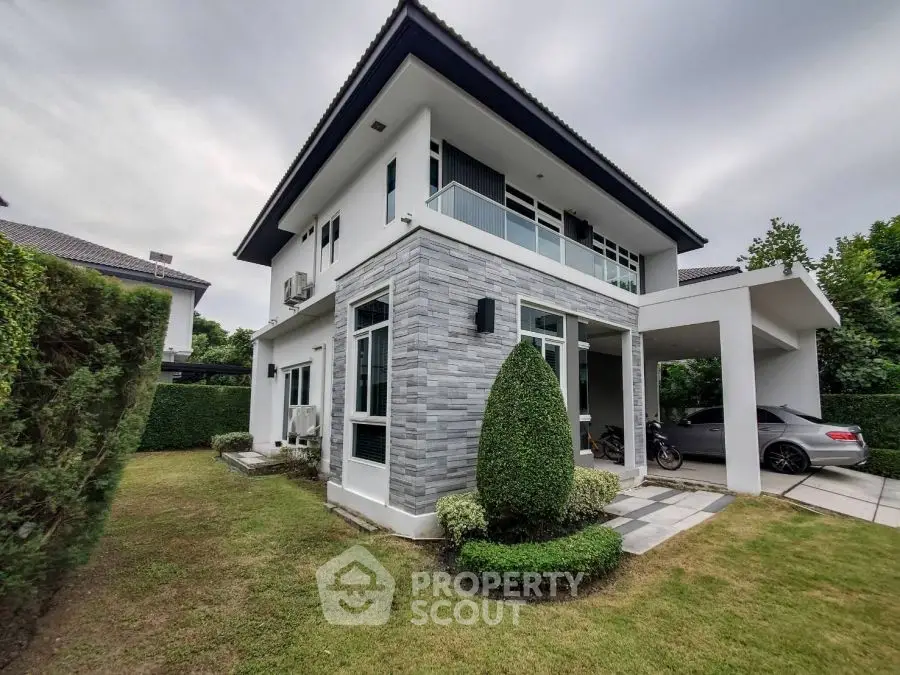 Modern two-story house with landscaped garden and carport in suburban setting.